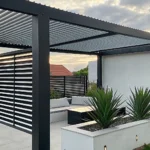 Modern patio pergola idea with a louvered roof and sleek outdoor furniture.