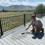 Utah homeowner gently cleaning a composite deck with a soft brush
